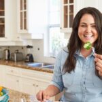 Woman eats healthy vegetables. She is working with a coach for positive mindset.